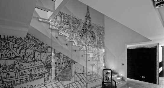 Mur en verre dans un escalier avec un mur représentant la ville de Paris